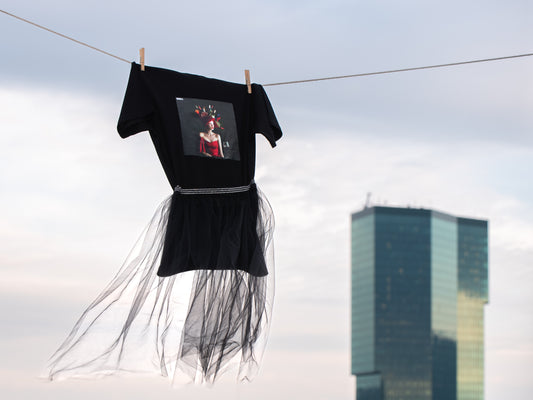 Black unisex T-shirt with AI-generated Hello Weekend print from M2ArtWear, styled with transparent skirt, blowing gently in the wind next to Prime Tower  in Zurich
